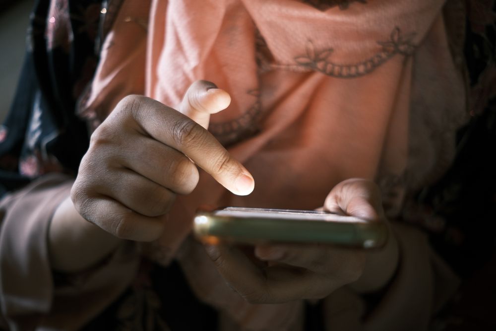 A visitor tapping through a form on their phone