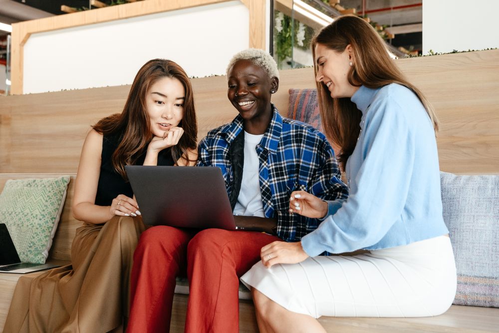 Three people looking at a laptop together